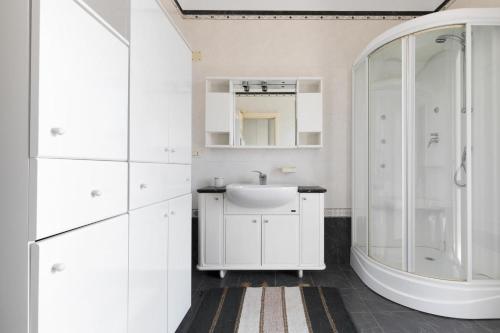 a white bathroom with a sink and a shower at La Villa Alba by BarbarHouse in Leporano Marina