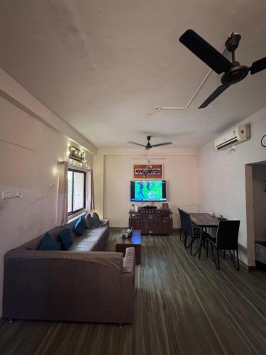 Una sala de estar con un sofá y un televisor de pantalla plana. en Homely, Secured, Privacy at Prime Location, en Vadodara