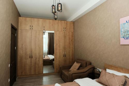 a bedroom with wooden cabinets and a bed and a couch at HD Didveli Apartment in Bakuriani