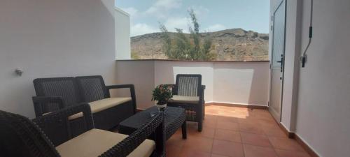 a balcony with chairs and a table and a window at Vv Faro in Puerto de Mogán