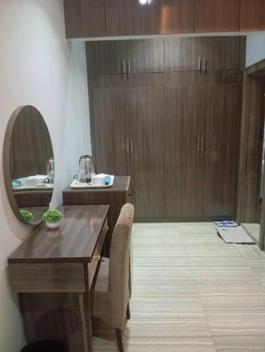a bathroom with a wooden table and a mirror at Walijam Bloom Luxury Suites in Kaduna