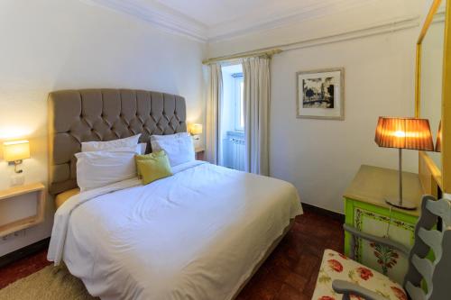 een slaapkamer met een groot wit bed en een raam bij Quinta dos Amigos in Almancil