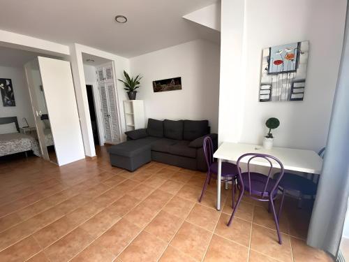 a living room with a couch and a table and chairs at Vv Velero in Puerto de Mogán