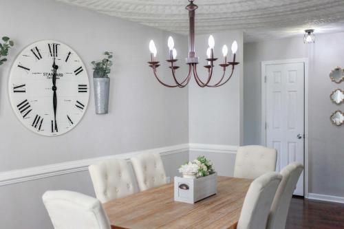 a dining room with a clock and a table and chairs at Sojourn Delightful Family Home Sleeps 6 in Norfolk