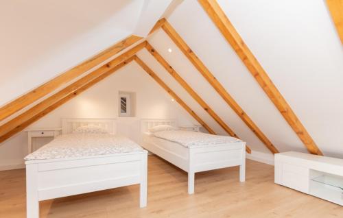 2 bedden in een zolderkamer met houten balken bij Villa Pave-Makarska by Villas Guide in Juričići