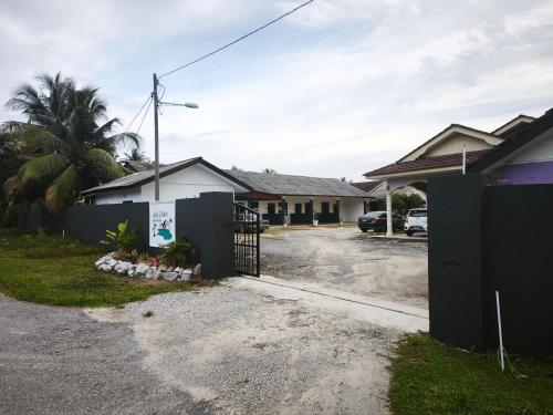 a house with a gate in front of a parking lot at OYO 91244 Aufa Chalet in Kuala Terengganu