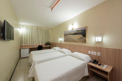 a hotel room with two beds and a television at Arrey Express Hotel - Teresina in Teresina