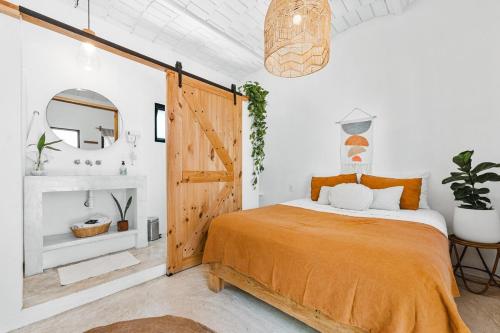 a bedroom with a bed and a wooden door at Downtown SURF SHACK- steps from main surf break in Sayulita