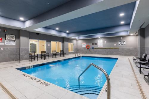 a pool in a hotel room with tables and chairs at Staybridge Suites London by IHG in London