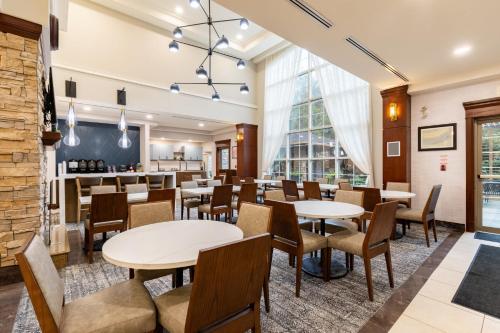 a restaurant with tables and chairs and a bar at Staybridge Suites London by IHG in London
