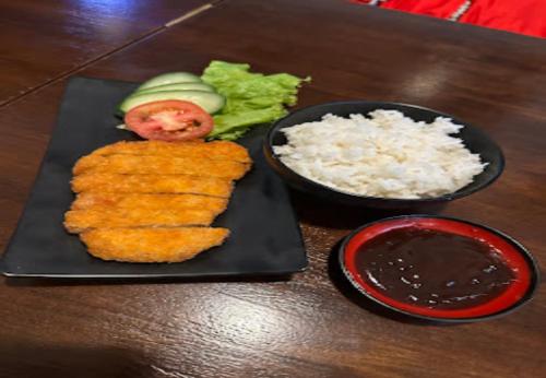 een zwart bord met eten met rijst en groenten bij Hotel Samurai Sanur in Sanur