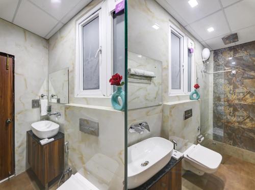 a bathroom with a sink and a toilet and a shower at Hotel Travana Stay at Pitampura in New Delhi