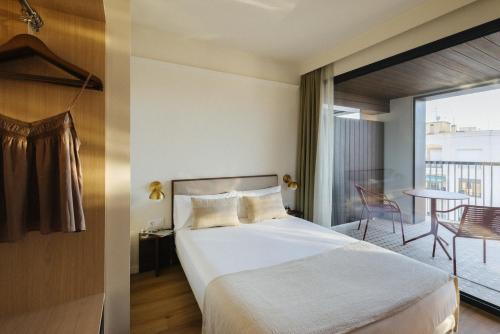 a hotel room with a bed and a balcony at Atipico Madrid in Madrid