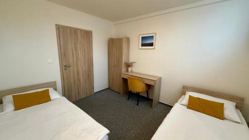 a hotel room with two beds and a desk at Chata Tale - Dom Horskej služby in Tale