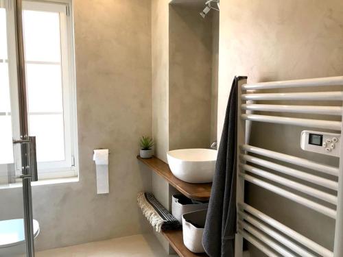 a bathroom with a white sink and a window at Le Sémillon in Bandol