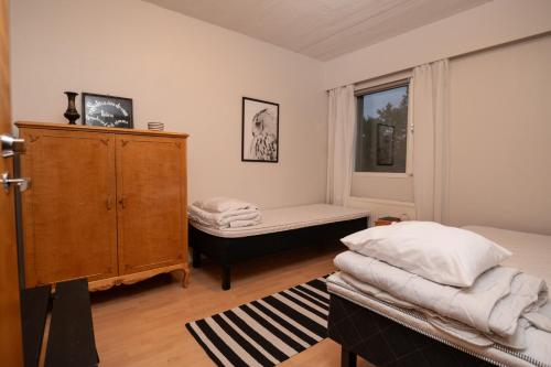 a bedroom with a bed and a dresser and a window at Mission Guesthouse in Gäddnäs