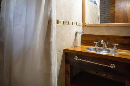 a bathroom with a sink and a shower curtain at Cabañas en Nono La Soñada in Nono