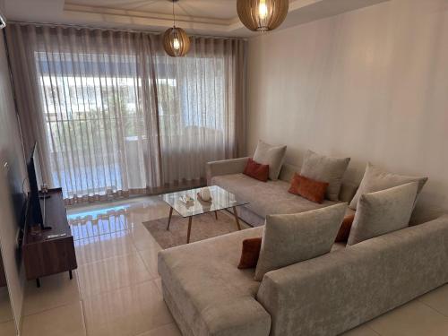 a living room with a couch and a table at BlueBreak Aourir in Aourir