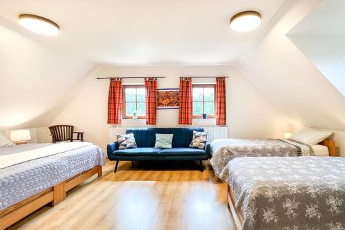 ヴルフラビーにあるCHALUPA Honzík - VILLA Vrchlabíの屋根裏のベッドルーム(ベッド2台、青いソファ付)
