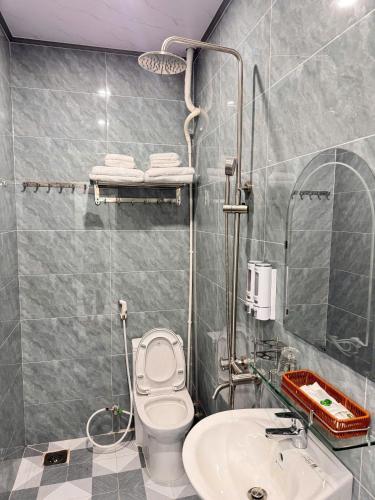 a bathroom with a toilet and a sink at Vinh Hotel in Thốt Nốt