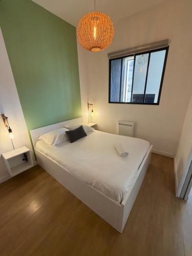 une chambre avec un lit blanc et une fenêtre dans l'établissement Proche Gare, parking couvert, Wifi, à Bourgoin-Jallieu