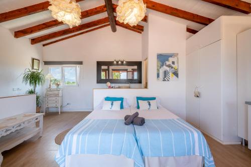 a bedroom with a large bed with blue and white sheets at Alegrías in Pla de na Tesa