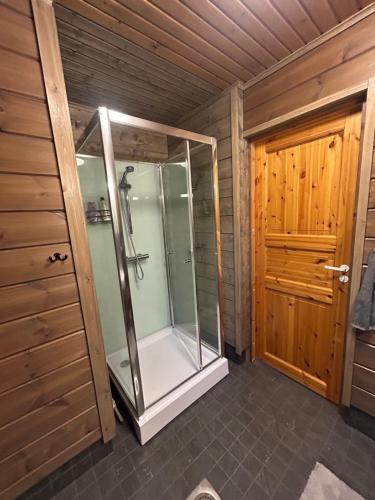 a walk in shower in a room with a door at Villa Hietikko in Kivijärvi