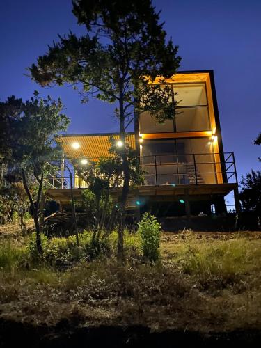 uma casa sentada no topo de uma colina à noite em Refugio Matanzas Loft con Jacuzzi privado em Pupuya