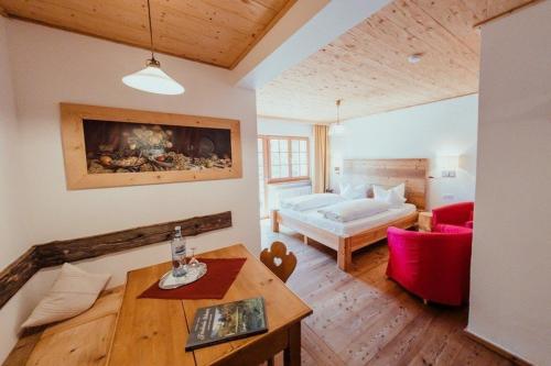 a living room with a bed and a table at Hotel Am Fichtelsee in Fichtelberg