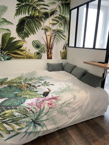 Bett in einem Schlafzimmer mit einem Wandbild aus Pflanzen in der Unterkunft Studio design hypercentre Gare & espresso offert in Castelnaudary