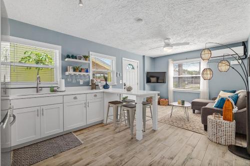 a kitchen with a sink and a table in a room at Déjà Blue - Steps to the Ocean! in St. Augustine