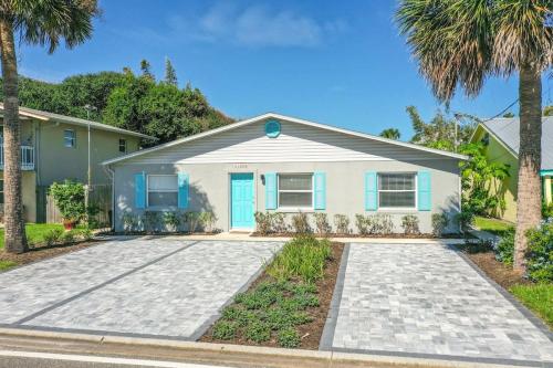 a house with a blue door and palm trees at Déjà Blue - Steps to the Ocean! in St. Augustine