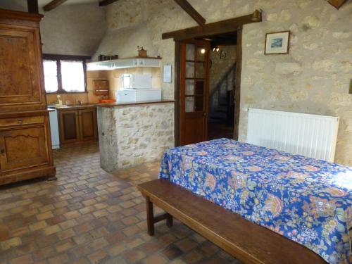 a bedroom with a bed and a kitchen at Le petit moulin in Journet