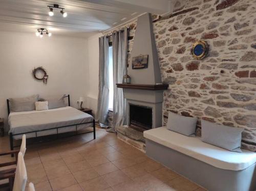 a bedroom with a bed and a stone wall at Charming Apartments in Trikeri Village in Tríkeri
