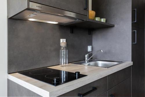 a kitchen counter with a sink and a bottle on it at Student Experience Granada - Luxury Hostel in Granada