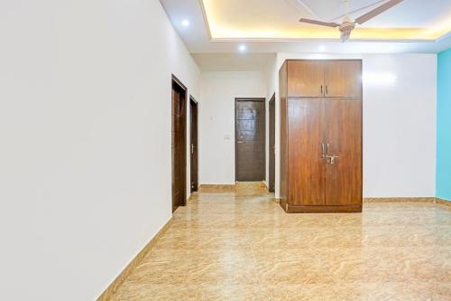 a hallway with a ceiling fan and a wooden door at Hotel O Yash stay in New Delhi