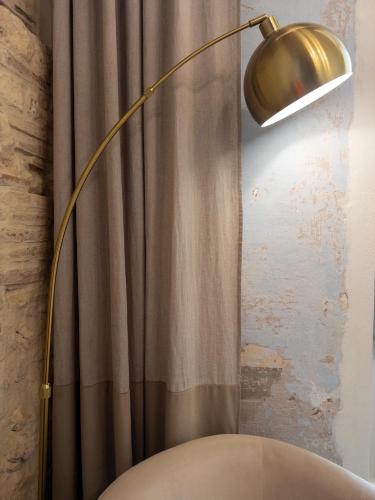 a gold floor lamp next to a shower curtain at Cielo Cagliari For2 Design - Comfort Solo Adulti in Cagliari