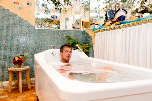 um homem numa banheira na casa de banho em Schlossberghof Marzoll em Bad Reichenhall