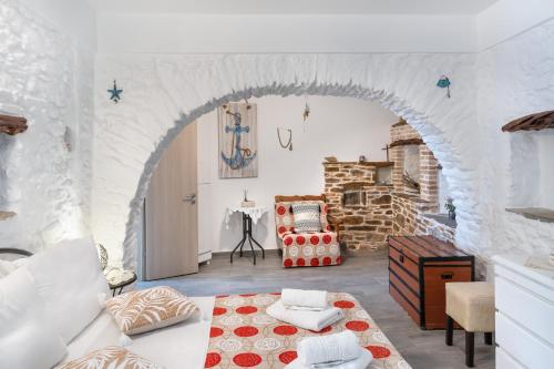 Una sala de estar con un arco y un sofá. en Olga's House kythnos D, en Kithnos