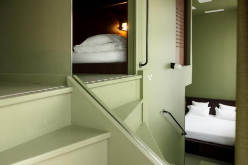 a small room with a mirror and a bed at The People Lyon Hostel in Lyon