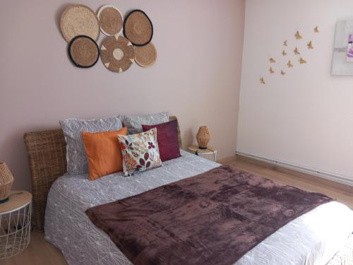a bedroom with a large bed with colorful pillows at Le Camus in Belonchamp
