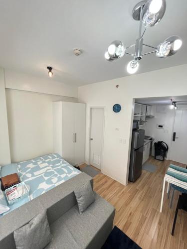 een slaapkamer met een bed en een tafel en een keuken bij Holly's Place by Motorists Transient House in Biñan