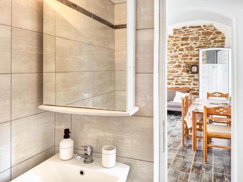 a bathroom with a sink and a dining room at Olga's House Kythnos in Kithnos
