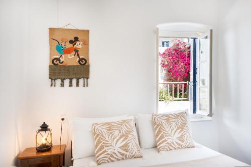 a white couch in a living room with a window at Olga's House Kythnos in Kithnos