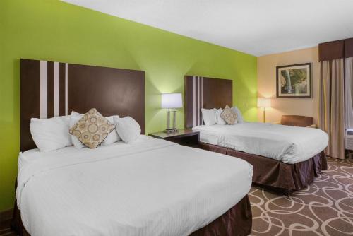 two beds in a hotel room with green walls at Best Western Lake Cumberland Inn in Monticello