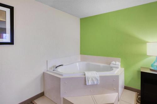a bathroom with a white tub in a green wall at Best Western Lake Cumberland Inn in Monticello