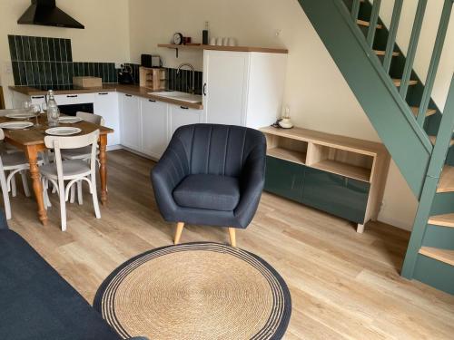 a living room with a blue chair and a table at Charming House in Beauvais in Beauvais