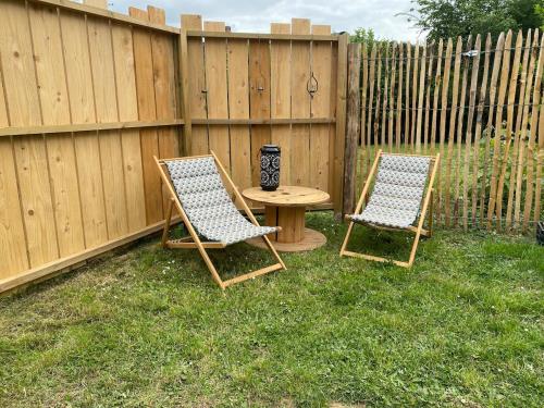 two chairs and a table next to a fence at Charming House in Beauvais in Beauvais