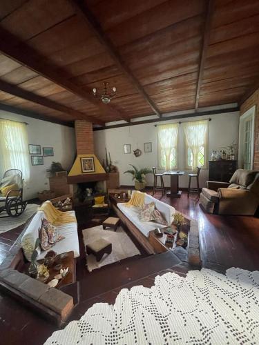 a large living room with couches and a fireplace at Refúgio Pasárgada Guest House in Mairiporã