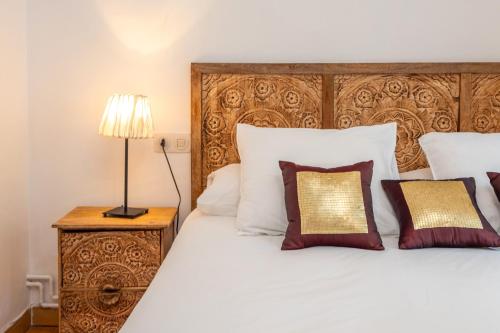 a bedroom with a large white bed with a wooden headboard at Apartamento con Jardin y Parking in Platja  d'Aro